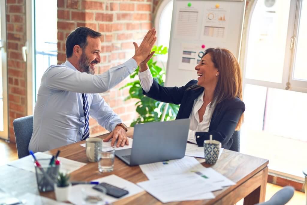 two coworkers giving each other a high five